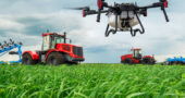 Modern technologies in agriculture. An industrial drone flies over a green field. tractors cultivate the soil in rural areas. The concept of technological agriculture